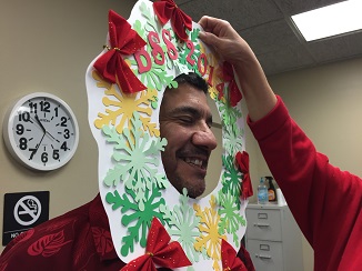 Pete Benavidez with his face sticking out of a Christmas Wreath